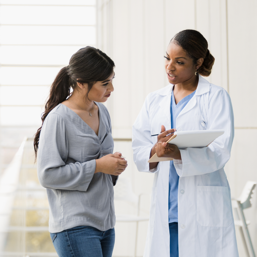 physician with a clipboard talking to a patient