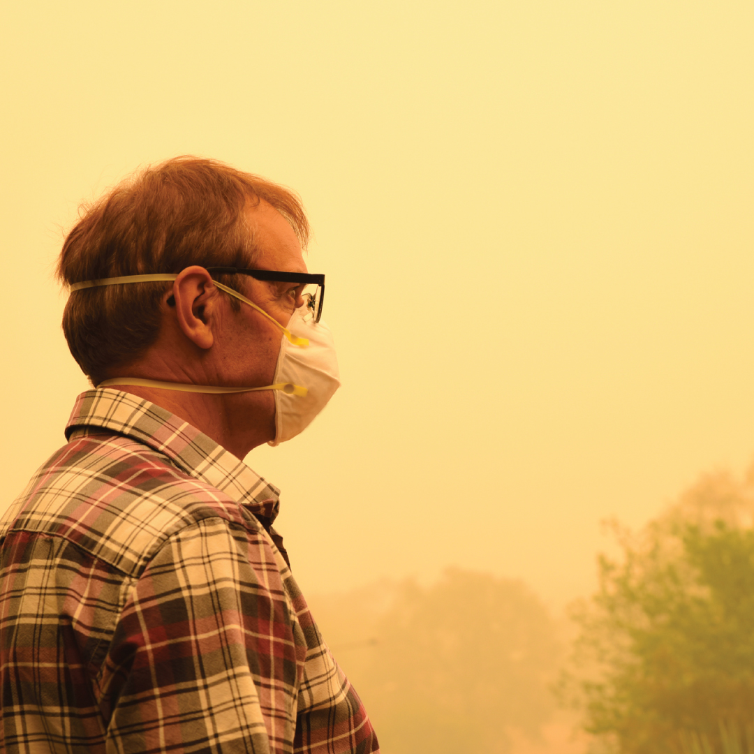 person standing in wildfire smog with a mask on